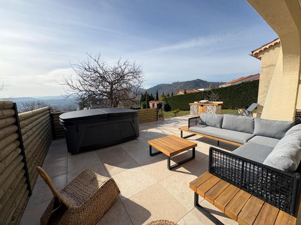 a patio with a couch and chairs and a hot tub at la casa bella vista in Enval