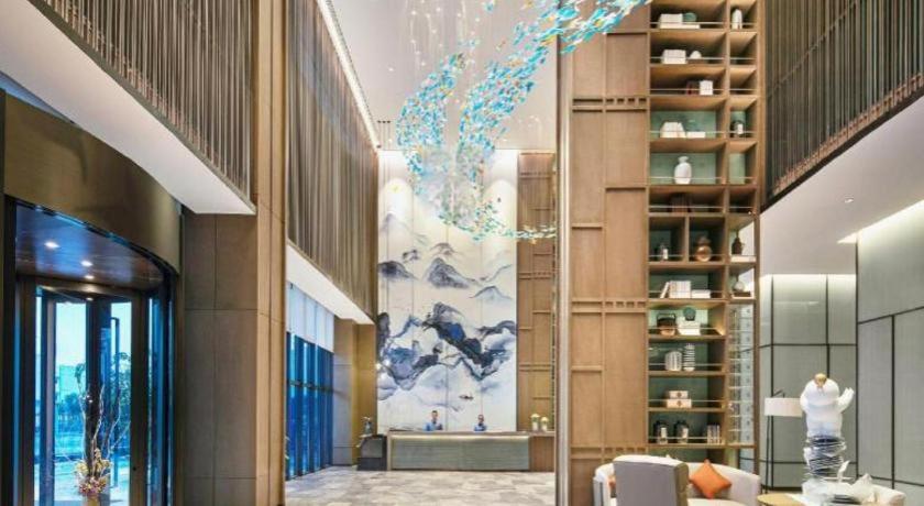 a lobby of a building with a painting on the wall at Wanda JIN Baise in Qitang