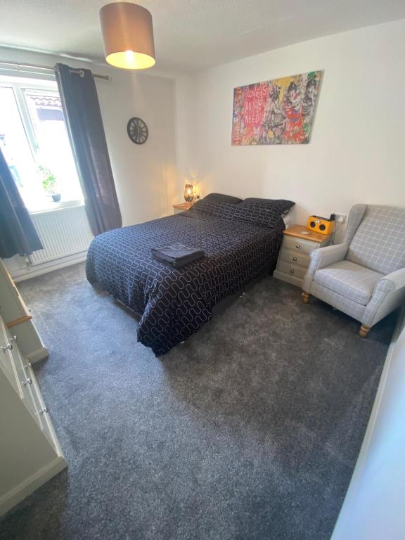 a bedroom with a bed and a chair at 5 Star Large Double Room in Hull with Free Parking & WIFI in Anlaby