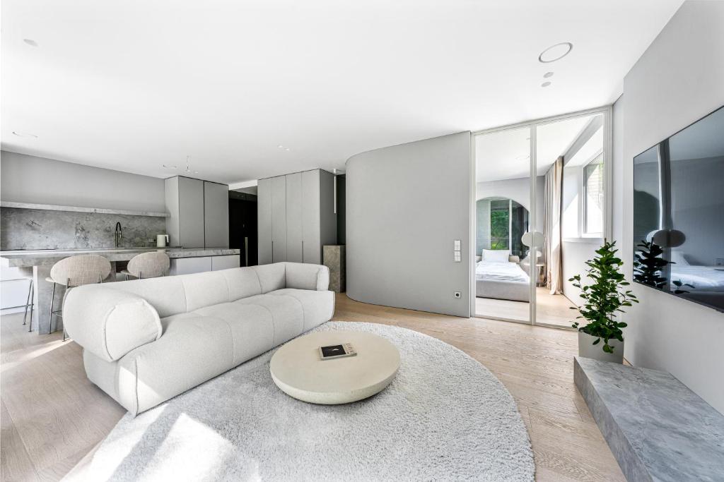 a living room with a white couch and a table at Refined luxury apartment surrounded by forest in Vilnius