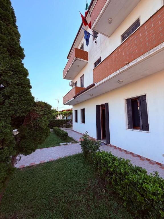 a building with a flag on the side of it at B&B Marku in Dëllinjë