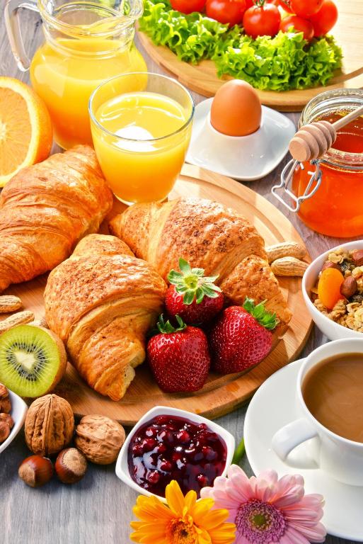 a breakfast of croissants and fruit on a table at Miodowy Zakątek Całoroczne Domki i Pokoje przy Suntago, Deepspot, Pyszne Śniadania, Grill in Mszczonów