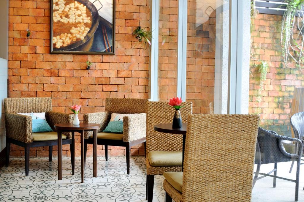 a patio with chairs and a table with a pizza at Kasemsarn Hotel Chanthaburi in Chanthaburi