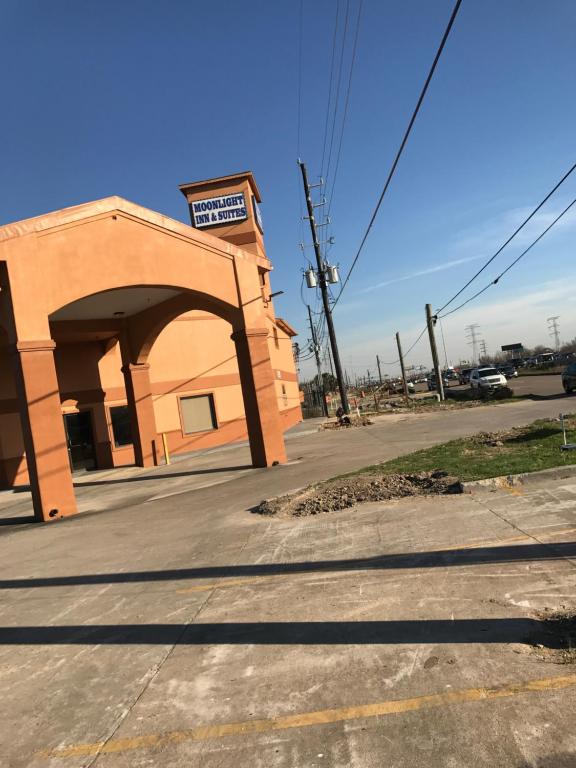 an orange building with an arch next to a street at Moonlight Inn & Suites in Houston