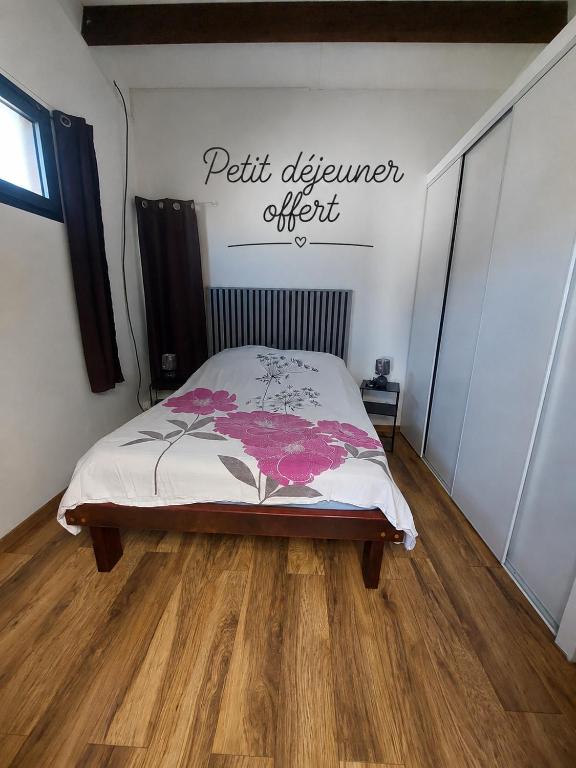a bedroom with a bed with a sign on the wall at L'Oreiller du Maïdo in Saint-Paul