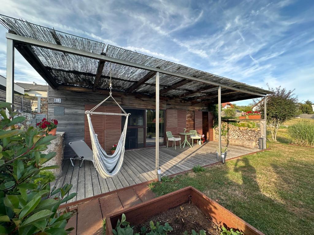a deck with a hammock and a house at Chalet im Mühlviertel in Schenkenfelden