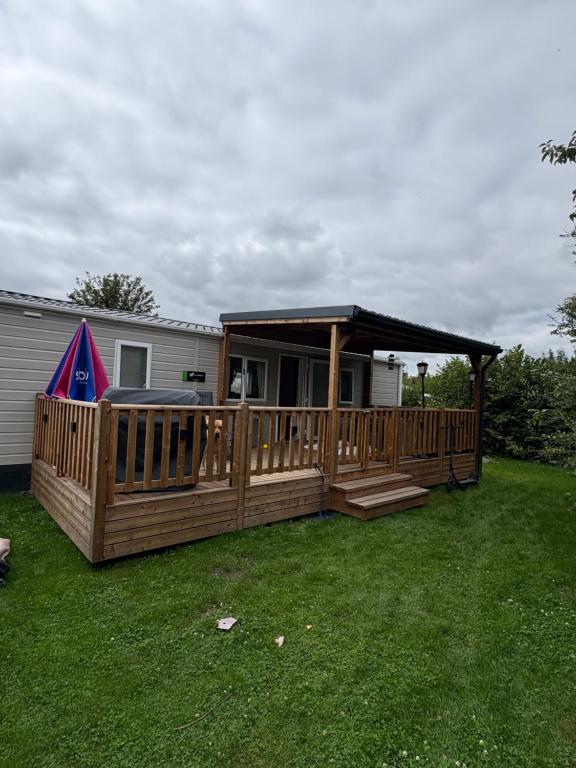 a wooden deck with a gazebo in a yard at Distel&Meer in Kropswolde