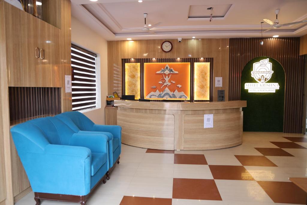 a waiting room with a blue chair and a counter at Shree Krishna Hotel & Restraunt in Pātolī