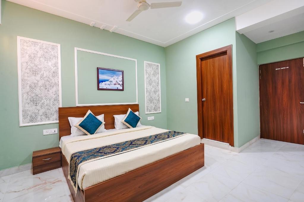 a bedroom with a bed with green walls and a wooden door at FabHotels Norvia in New Delhi