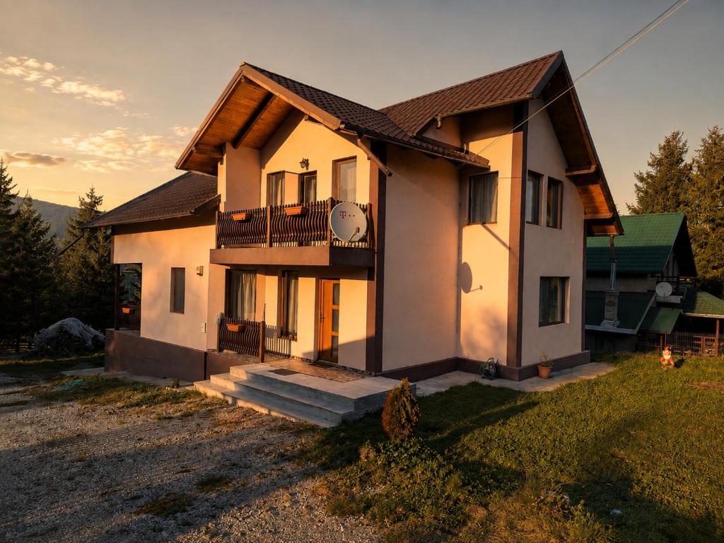 a house with a balcony on the side of it at Casa Dragomir in Plaiu Şarului