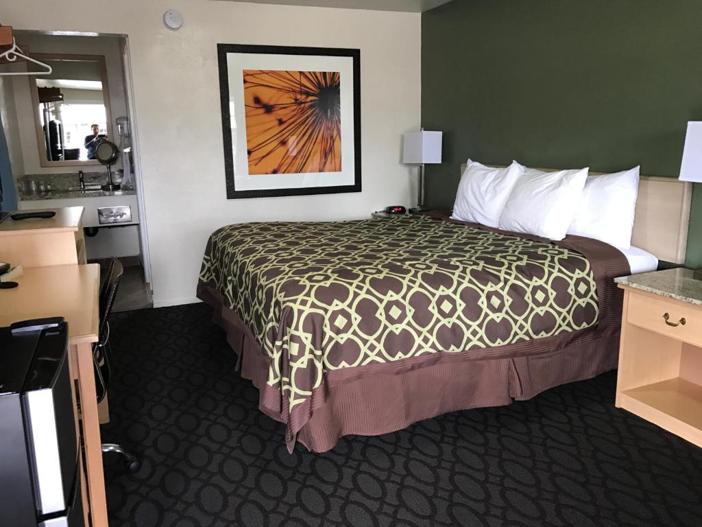 a hotel room with a bed and a painting on the wall at Downtown Inn in Eugene