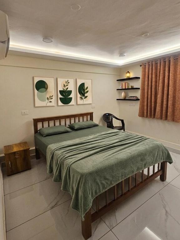 a bedroom with a large bed with a green blanket at Tvm stays in Trivandrum
