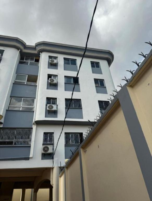 a tall white building with windows on the side of it at Nandys lounge in Yaoundé