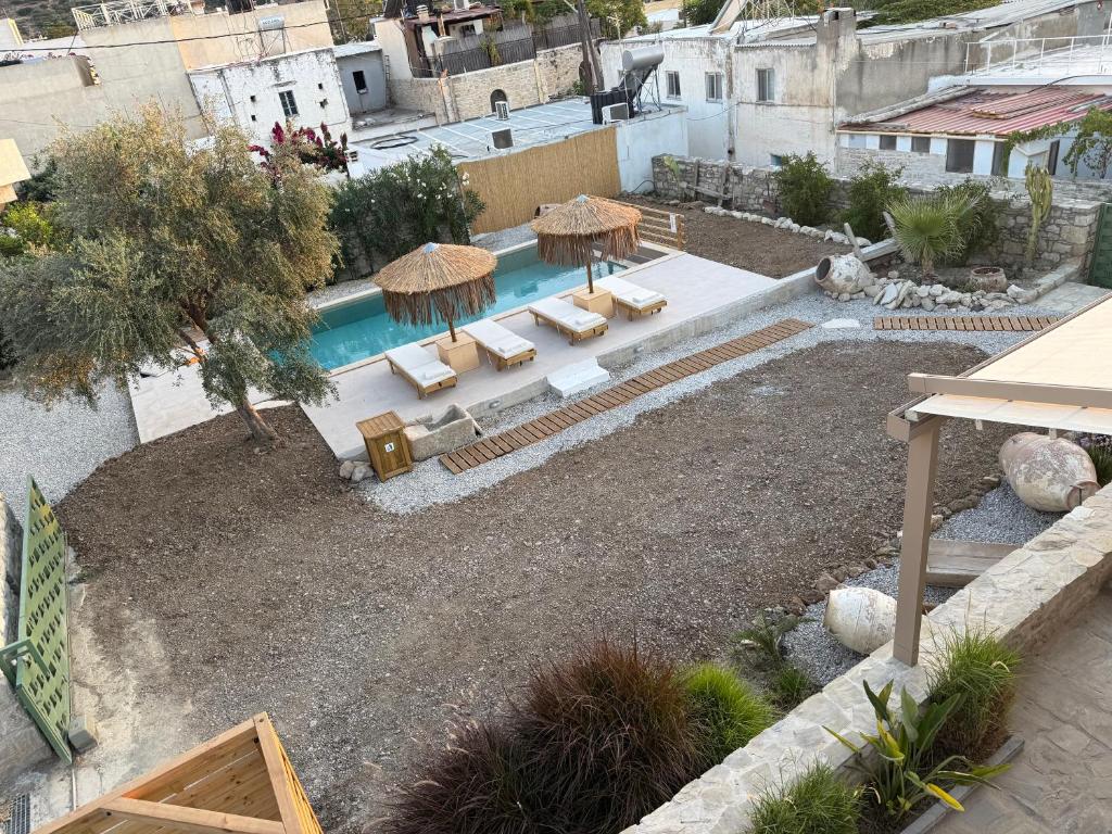 an overhead view of a pool with chairs and umbrellas at Papadia Luxury Apartments in Pitsidia