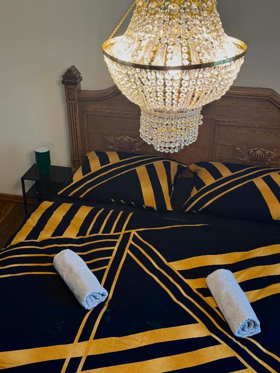 a bedroom with a black and yellow bed with a chandelier at R Limoli Cozy in Trávnica
