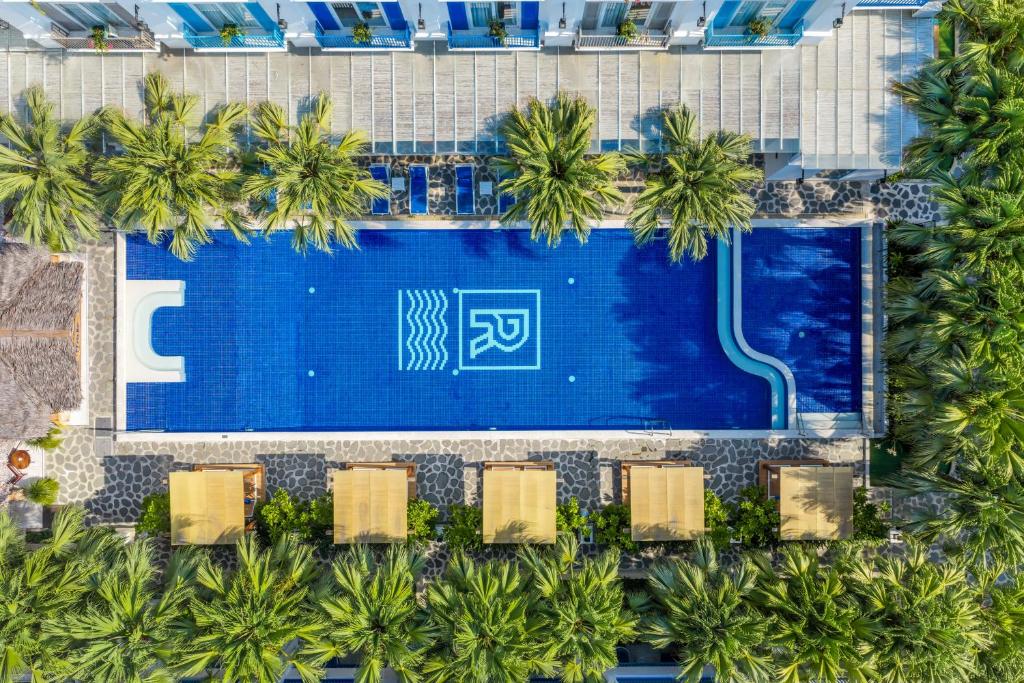 an overhead view of a swimming pool with palm trees at Risemount Premier Resort Da Nang in Danang