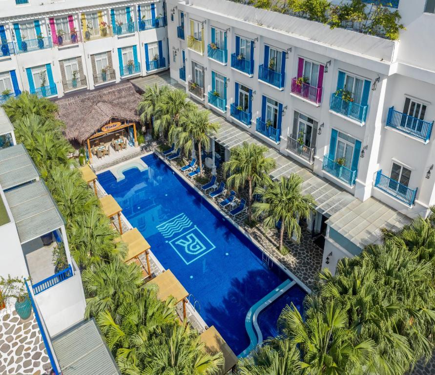 Aerial view of the main pool enclosed by colorful balconies and tropical planting.
