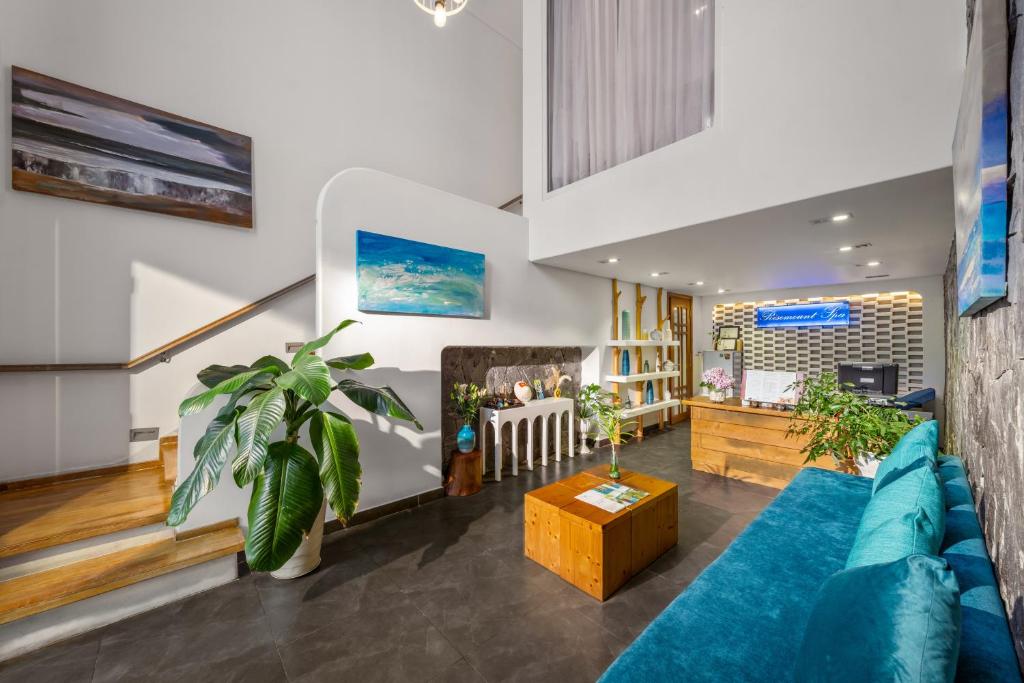 A colorful lobby lounge combines a blue sofa with a reception counter and staircase.