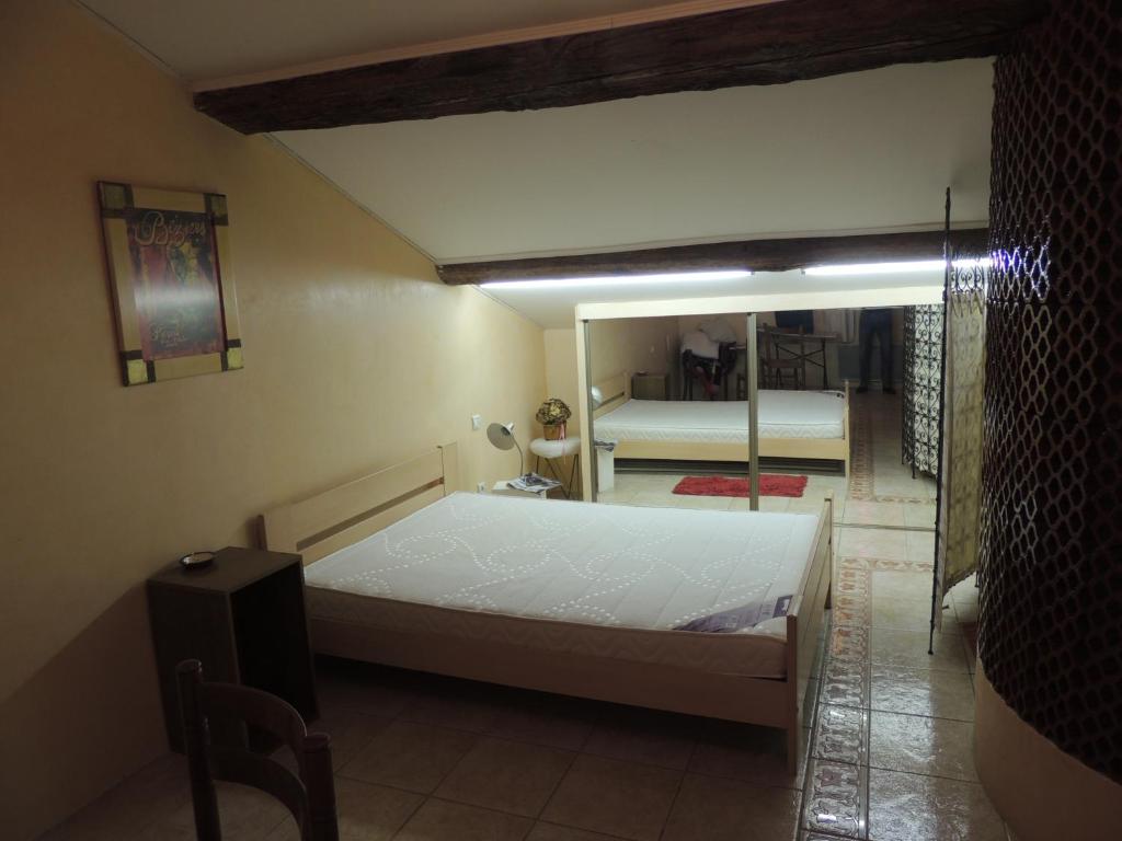 a bedroom with a white bed and a mirror at Chambres GAMBETTA in Béziers
