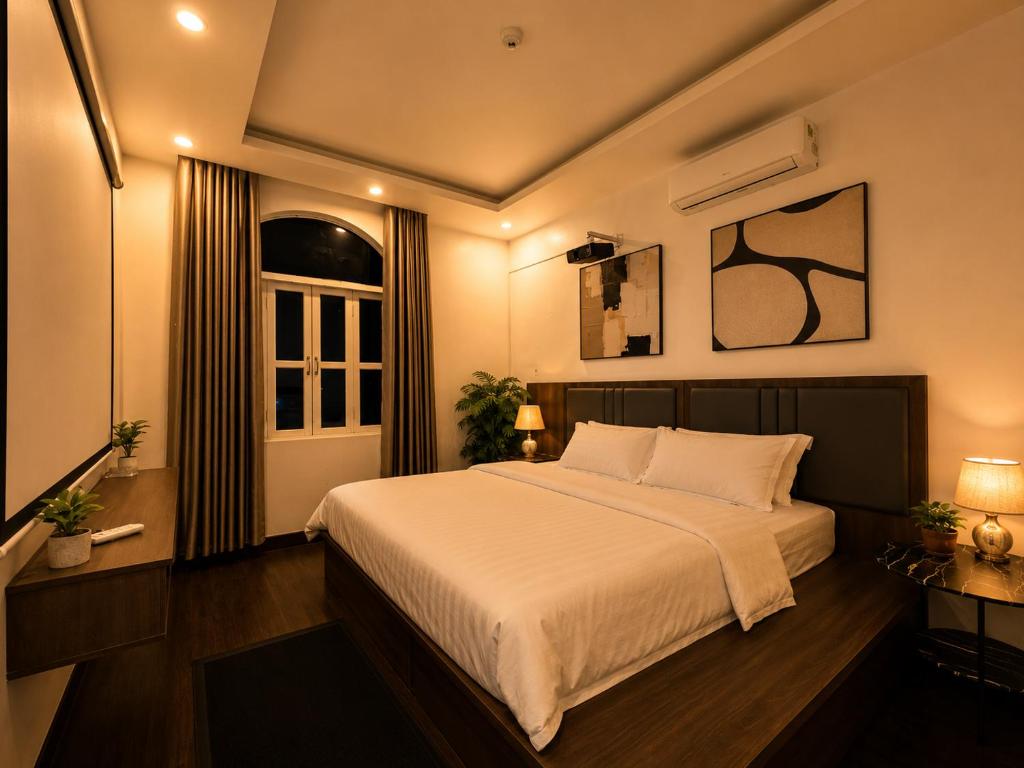 a bedroom with a large white bed and a window at Moonland Hotel in Phương Lăng