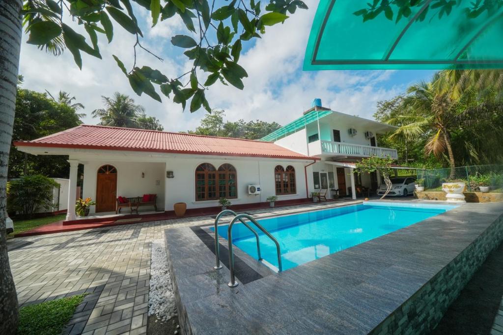 a house with a swimming pool in front of it at Ocean villa in Hiriketiya