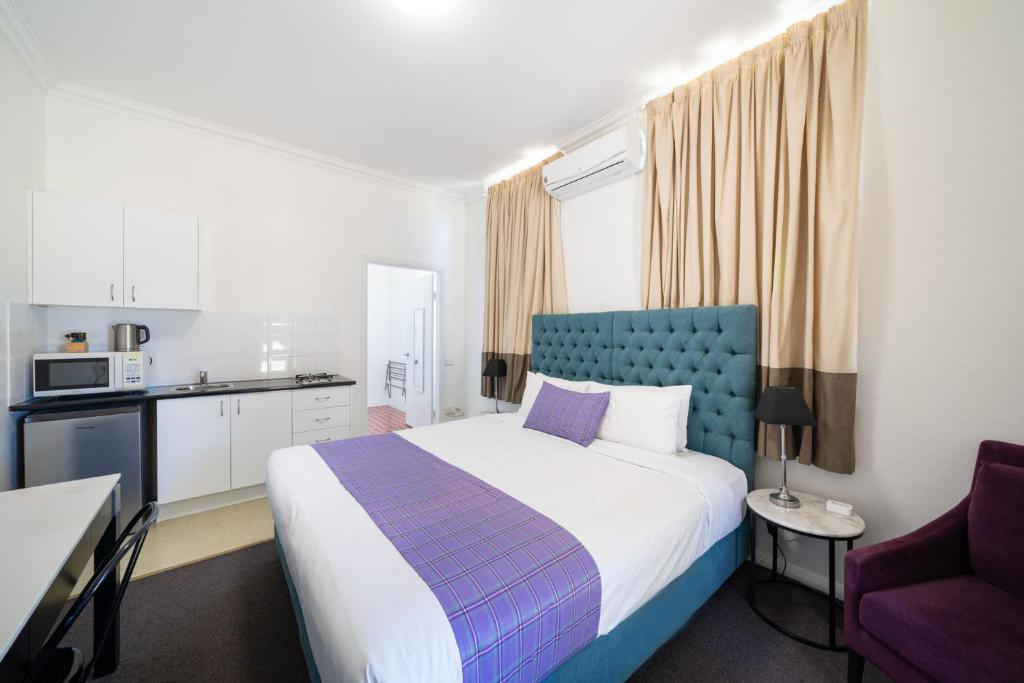 a hotel room with a bed and a kitchen at The Hallows Accommodation in Bathurst