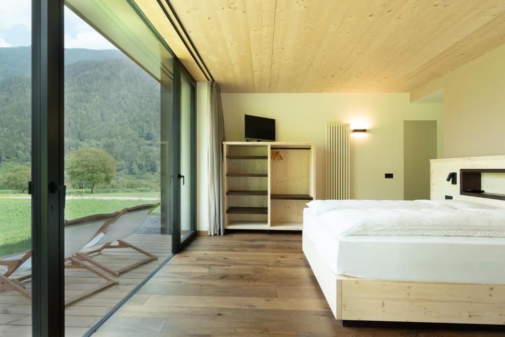 a bedroom with a bed and a sliding glass door at Agriturismo Maso Loera in Pelugo