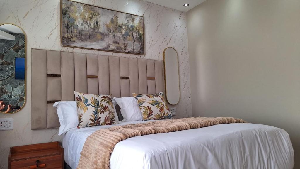 a bedroom with a large bed with white sheets and pillows at Nao's Place in Dorchester Heights 