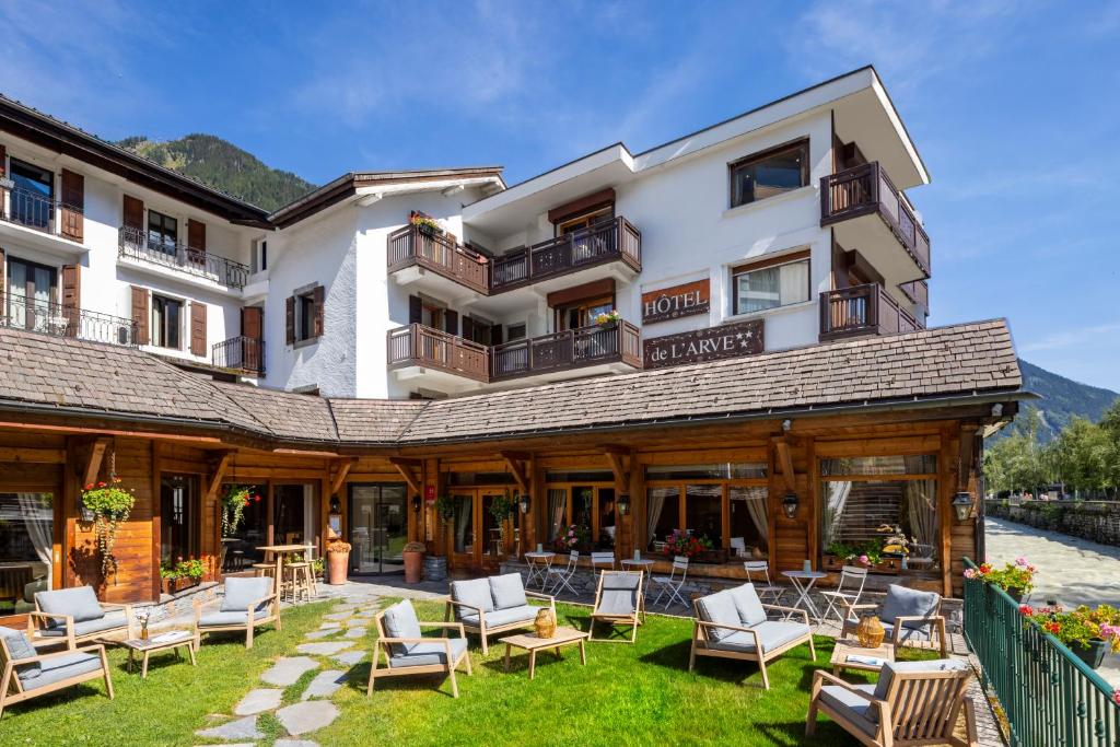 a hotel with chairs and tables in front of it at Hôtel de L'Arve by HappyCulture in Chamonix