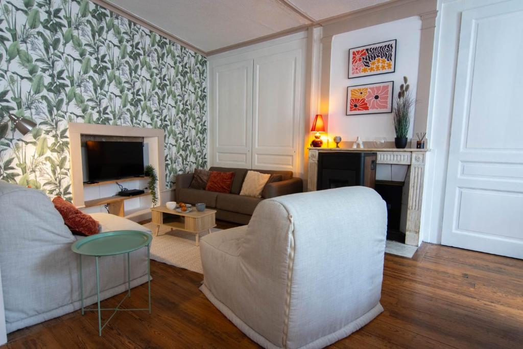 a living room with a couch and a fireplace at L'échappée Jurassienne - Tout équipé au calme in Saint-Claude