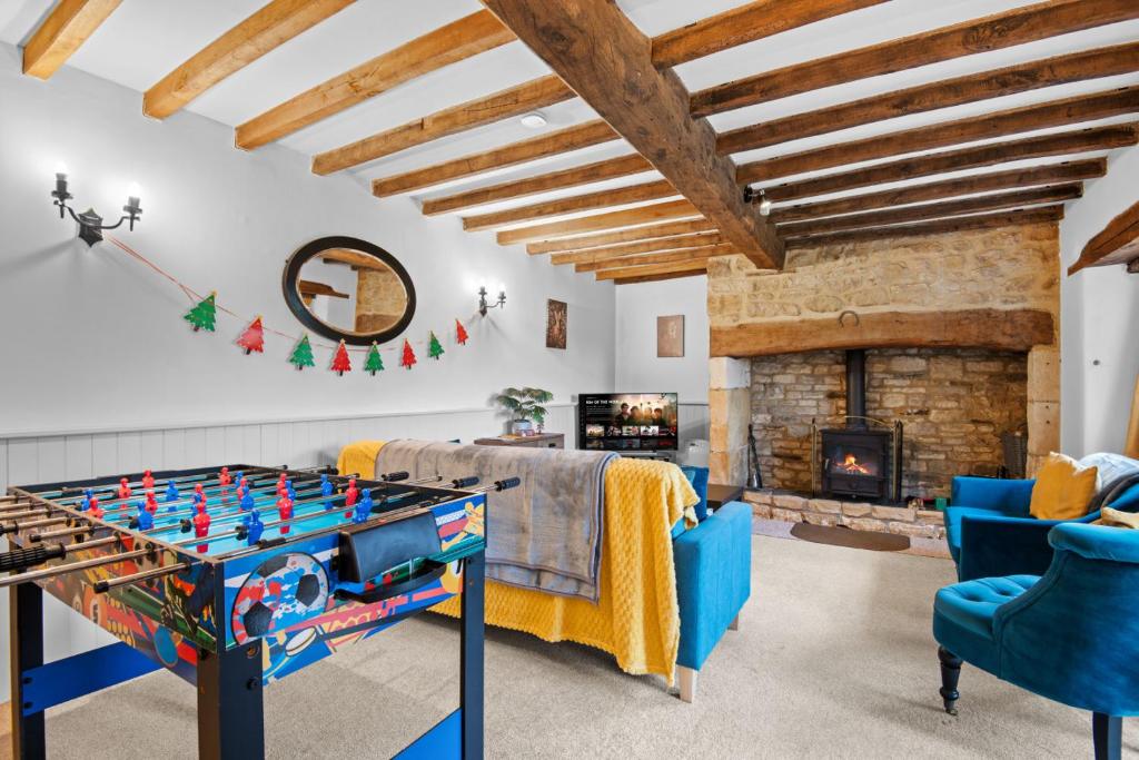 a living room with a foosball table and a fireplace at Traditional Cotswold escape with garden and fireplace in Cheltenham