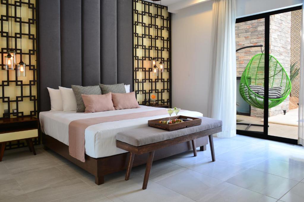 a bedroom with a large bed and a table at Elements Tulum Boutique Hotel in Tulum