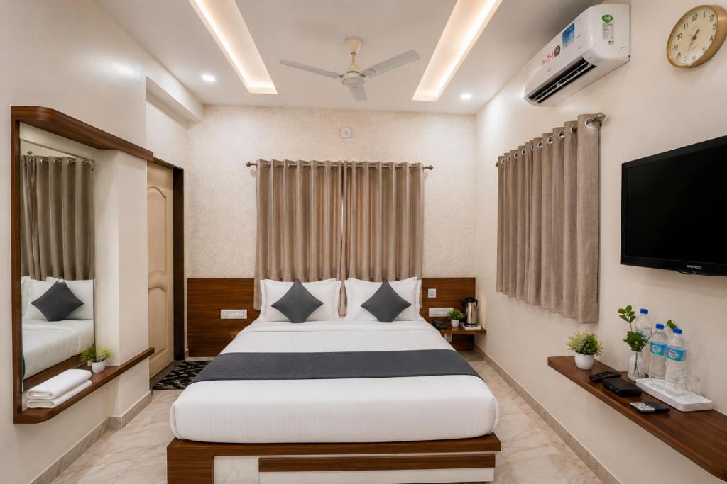 a hotel room with a bed and a flat screen tv at Hotel Bhakti Rajkot I Hotel in Rajkot I Best Hotel in Rajkot in Rajkot