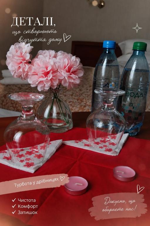 a table with two bottles of water and pink flowers at Готель Аркан in Kolomiya