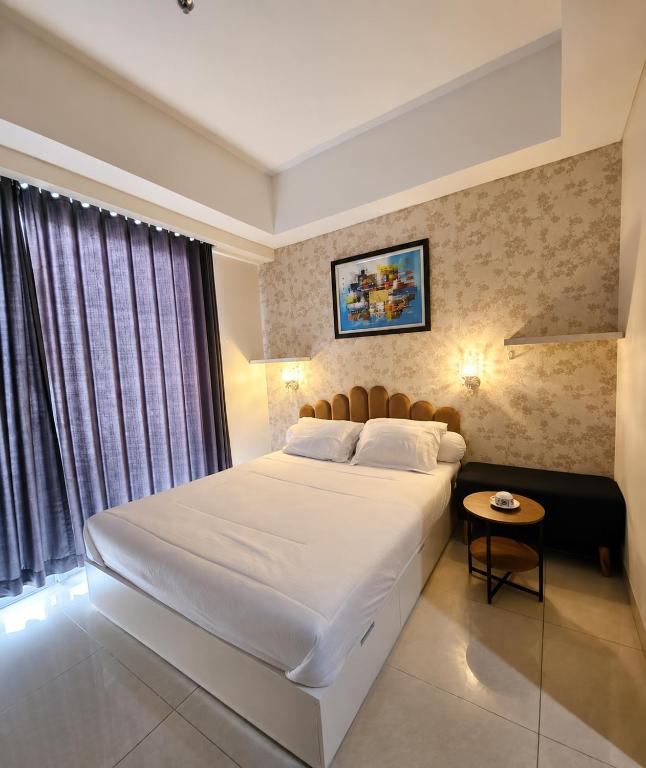 a bedroom with a large white bed and a window at Modern studio with a stûnning view at 32 floor in Jakarta