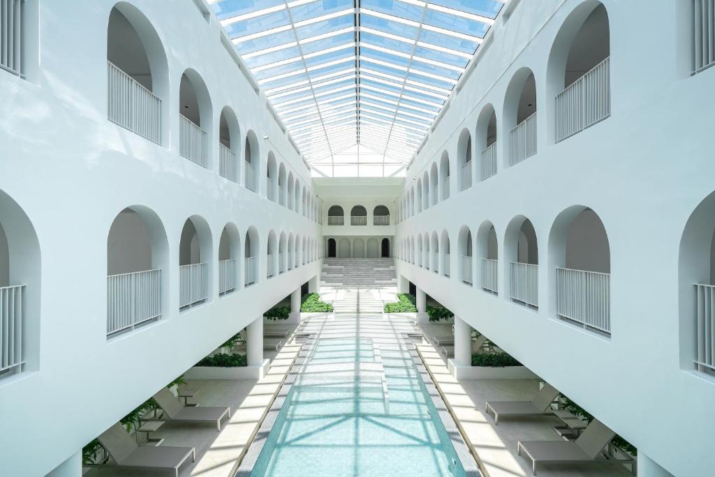 an empty hallway of a building with a glass ceiling at Away Bangkok Riverside Kene in Bangkok