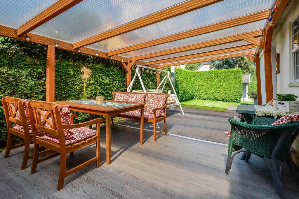 a patio with a table and chairs under a pergola at Ferienhaus Rauchfangswerder in Berlin