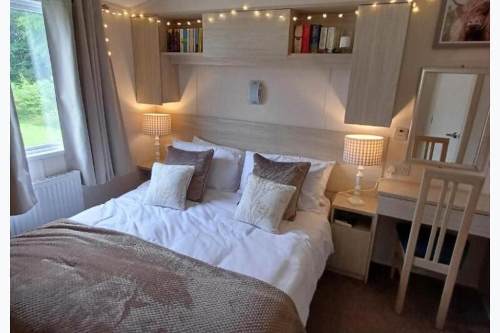 a bedroom with a bed with white sheets and pillows at 3-Bed Caravan Sleeps 7 with Indoor Pool in Wigton