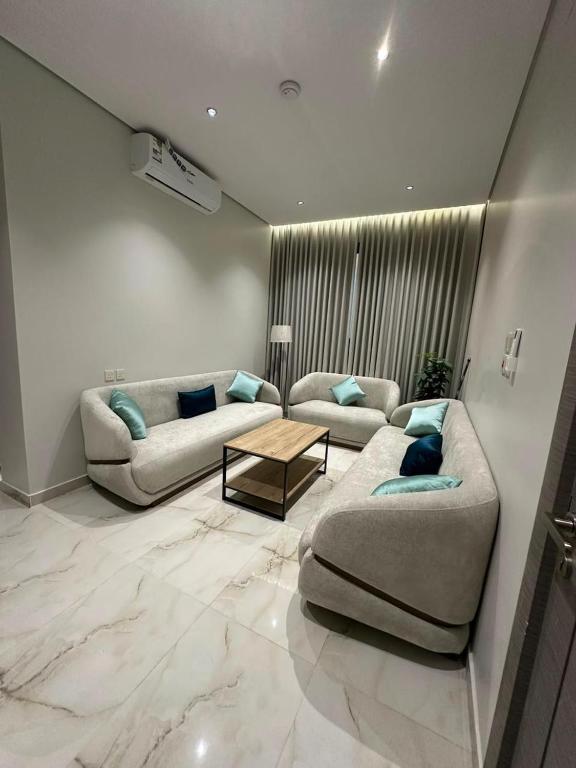 a living room with two couches and a table at خالد للشقق in Ar Rass