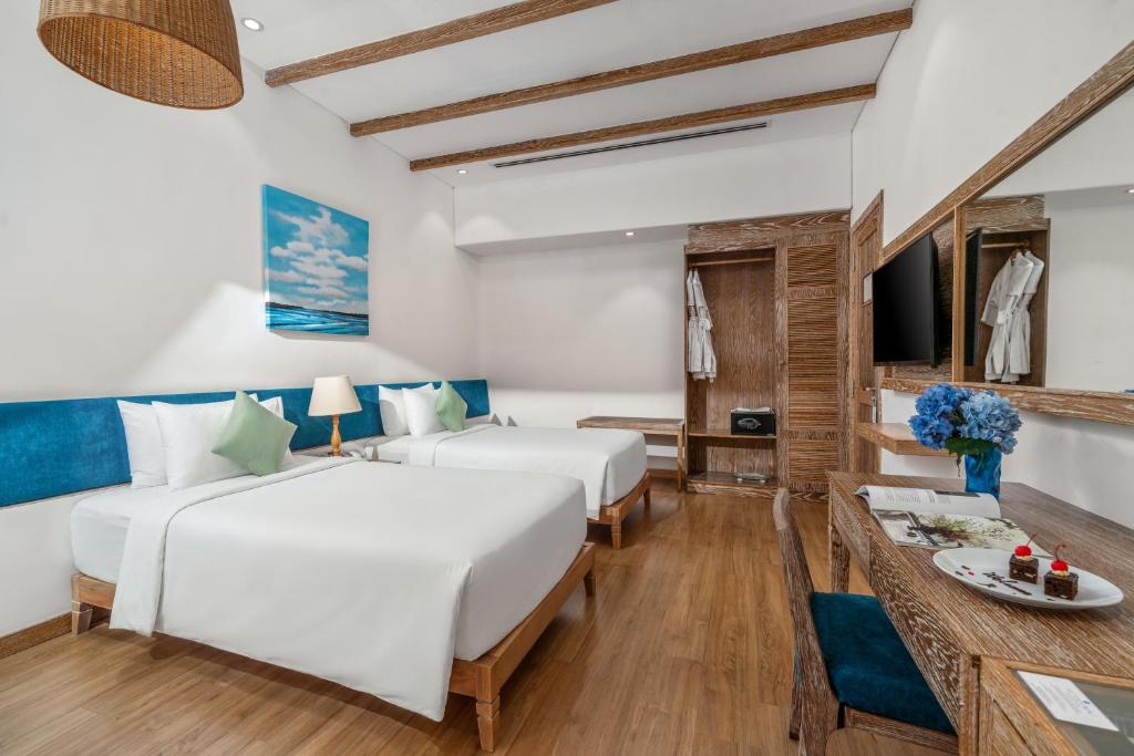 A twin bedroom with mirrored storage, a vanity desk and a small refreshment setup.