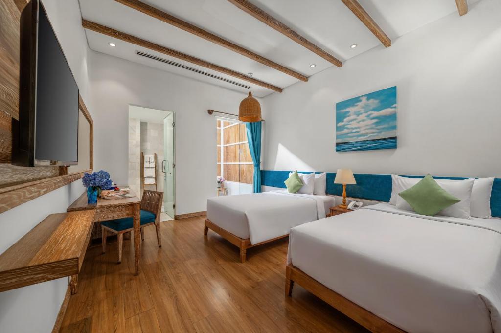 A twin room with two beds, a wall-mounted television, desk and balcony doors.