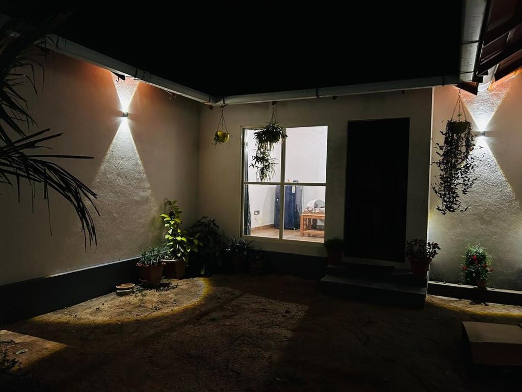 a dark room with a window and plants in it at Janapriya Villa 2 in Mudigere