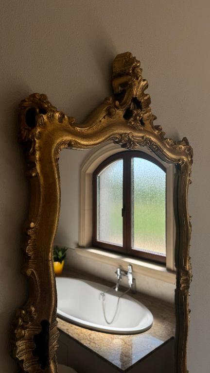 a mirror in a bathroom with a sink and a window at R Limoli Vintage in Trávnica