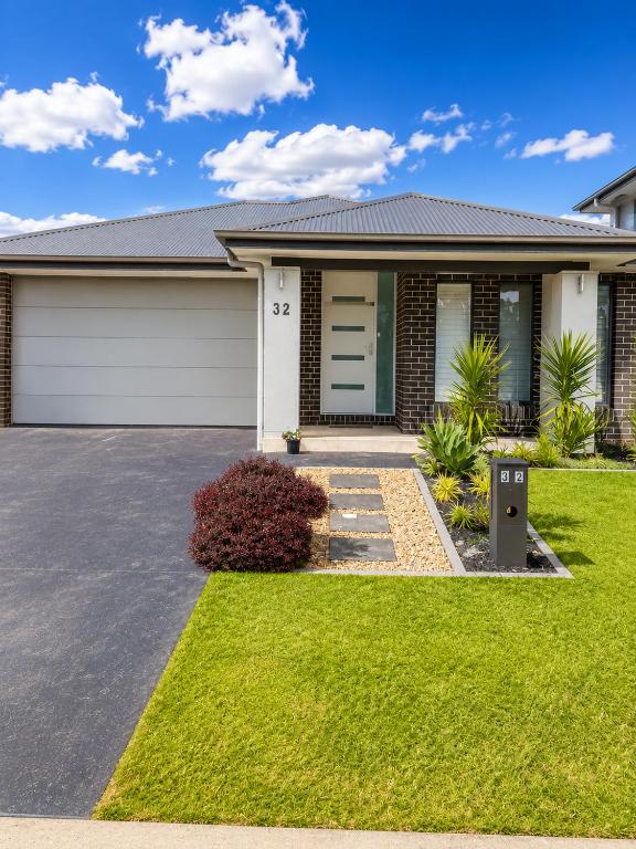 a house with a driveway in front of it at 4 Bedrooms Home in Gledswood Hills