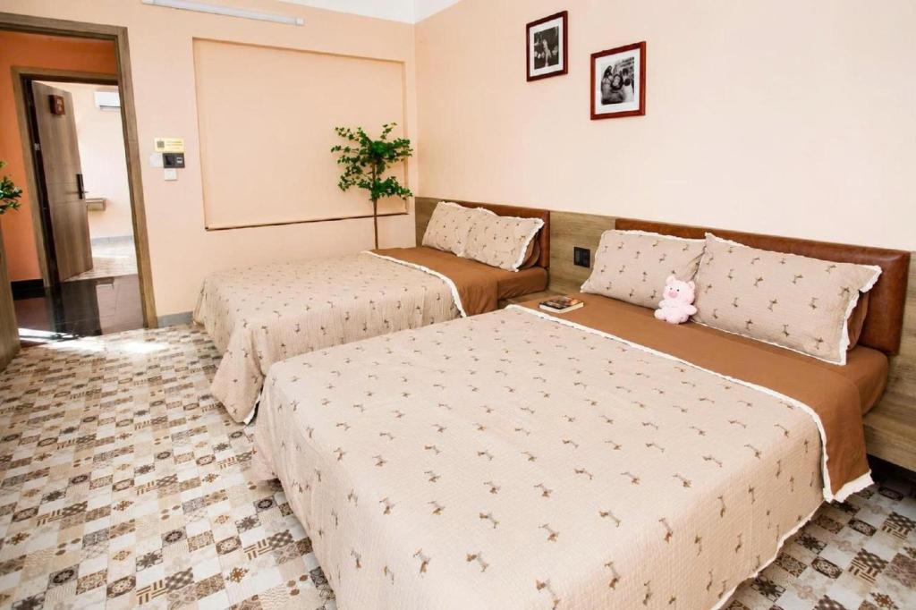 a hotel room with two beds and a couch at 2MINZ Homestay in Thôn An Hòa