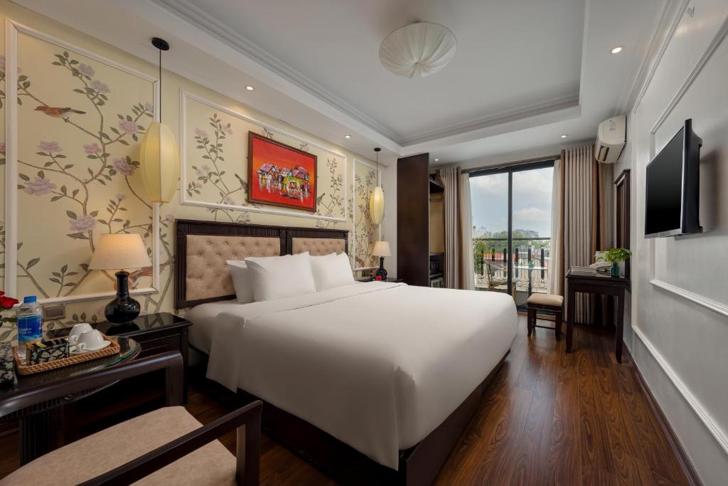a bedroom with a large white bed and a window at Golden Legend Boutique Hotel in Hanoi