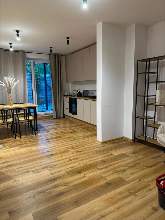 a kitchen and dining room with a wooden floor at Apartament Venis ul Jodłowa in Opole