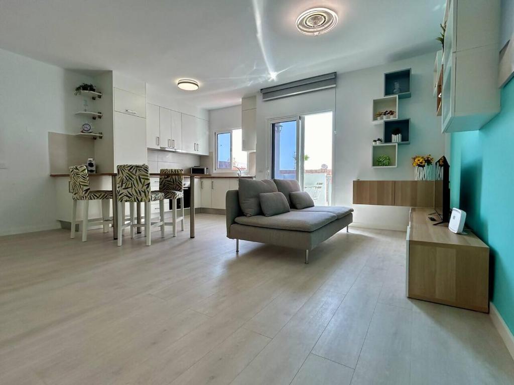 a living room and kitchen with a couch and a table at Casa Miami Alcalà in Alcalá
