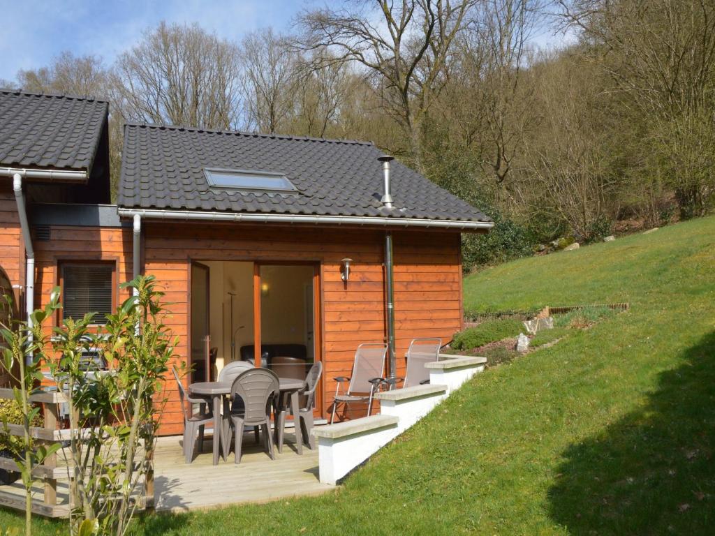 a cabin with a deck with chairs and a table at Cottage in Aywaille with Garden in Aywaille