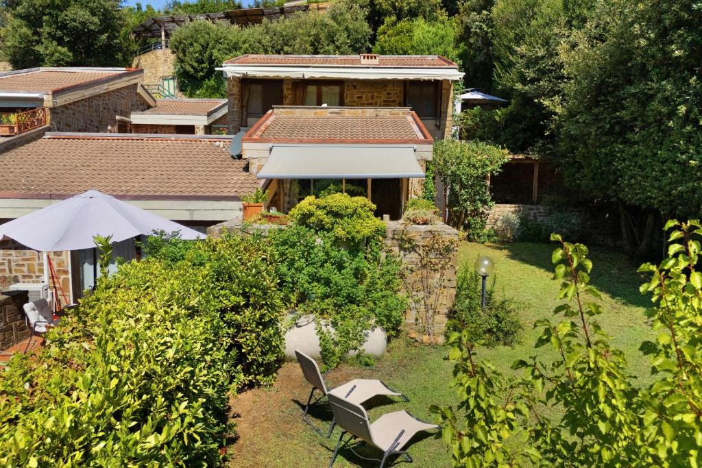 a garden with two chairs and an umbrella at Angolo di Paradiso in Punta Ala